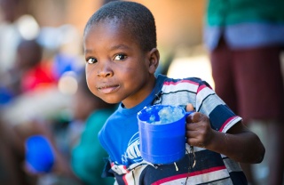 Child holding mug of Marys Meals