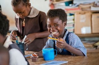 Child in Zambia enjoying Marys Meals in class
