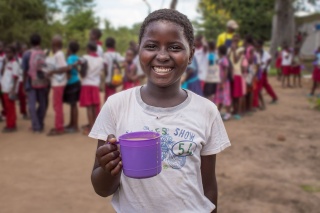 Child holding mug of food