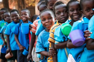 Children queueing with mugs