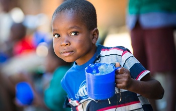 Child holding mug of Marys Meals