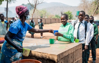 child receiving serving of Mary's Meals
