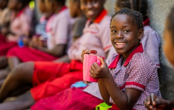 image of a happy child holding their school meal
