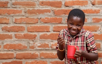 Image of a happy child holding their school meal