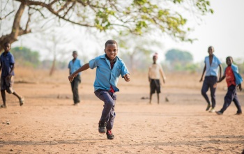 A boy, Falio, running outside in Zambia