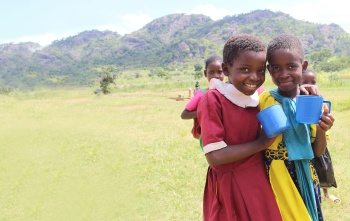 Image of children in Malawi holding mugs of porridge