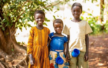 Three children standing with mugs