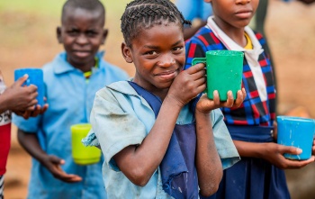 Image of a happy child holding their meal