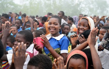 Children smile as they line up for porridge in Malawi.