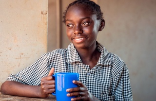 Child with thier nutritious mug of Marys Meals