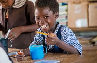 Girl in Zambia eating Marys Meals