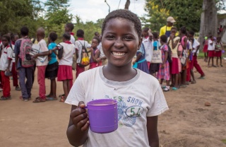 Child holding mug of food