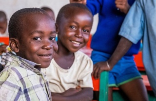 Two children smiling sitting in a classroom