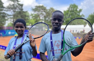 Hannah and Patrick holding up tennis rackets