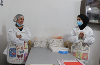 Two cooks standing in kitchen in Lebanon looking across at each other