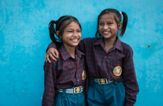 Siblings Jainab and Jubaida stand together smiling