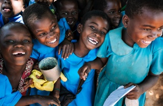 four girls smiling, holding cups