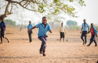 A boy, Falio, running outside in Zambia