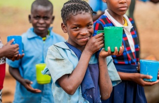 Image of a happy child holding their meal