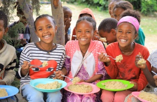 An image of three children in Ethiopia eating their school meals
