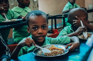 Boys in Haiti classroom eating from a boy
