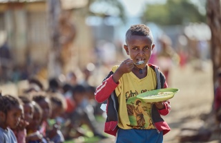 Boy eating porridge in Ethiopia
