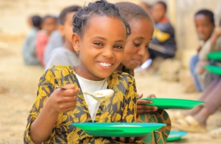 An image of a child in Ethiopia eating their school meal