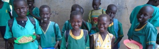 Smiling children with plates of Mary's Meals in South Sudan