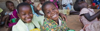 children smiling with mug of porridge