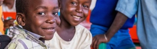 Two children smiling sitting in a classroom