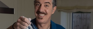 Giuseppe Dell'Anno in his kitchen sprinkling flour on dough