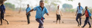 A boy, Falio, running outside in Zambia