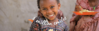 child smiling to camera with red plate and spoon with food - text overlay with 3 million smiles