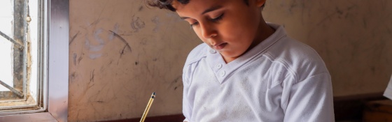 Young boy reading from a school book