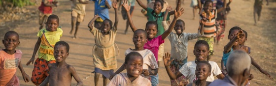 Children run together as they play outside a school