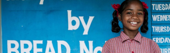 Image of a child in India about to receive her daily school meal