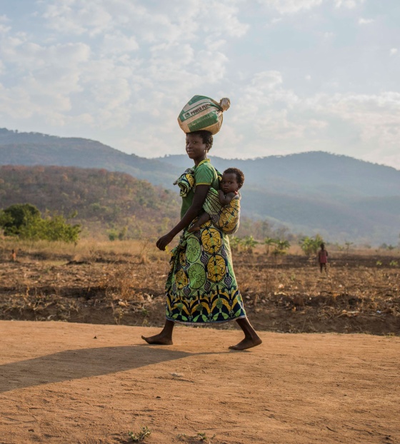 Woman carrying food bag to make Marys Meals