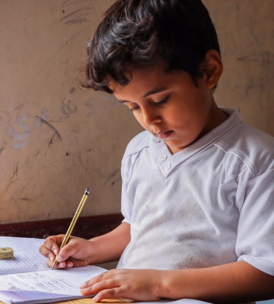 Young boy reading from a school book