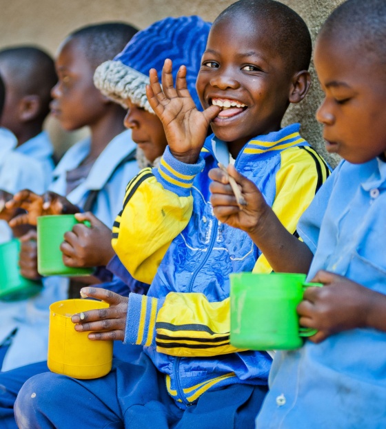 Children eating mugs of porridge