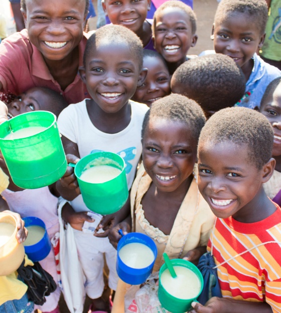 Smiling group of children with mugs of porridge