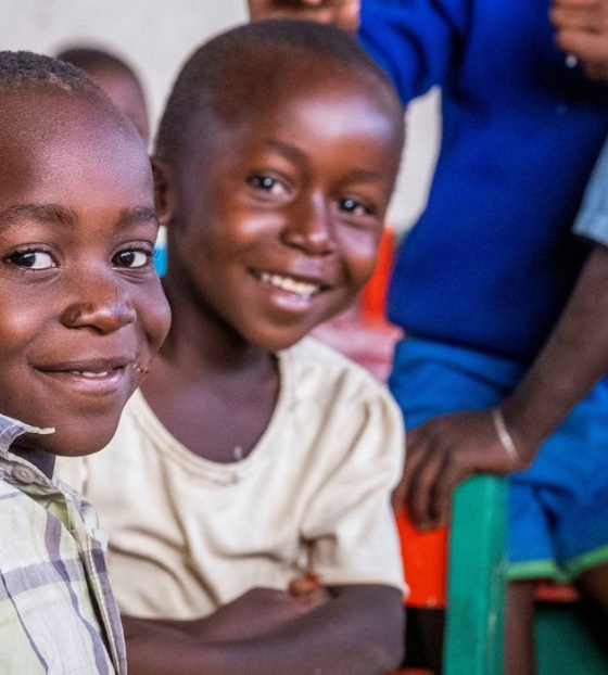 Two children smiling sitting in a classroom