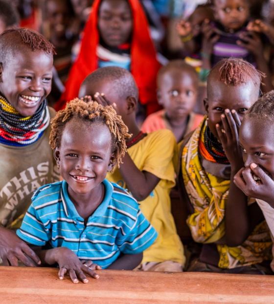 Children in a classroom sitting a table and laughing with each other