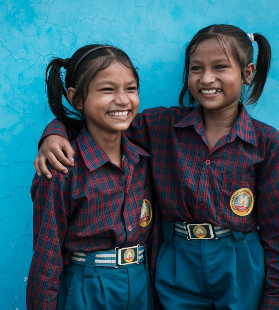 Siblings Jainab and Jubaida stand together smiling
