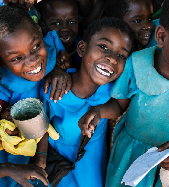 four girls smiling, holding cups