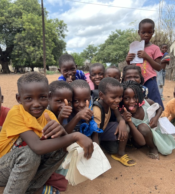 A group of happy children siting outside in Mozambique