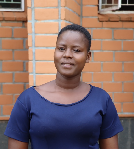 A young woman, Bernadette, stands outside the school she teaches at