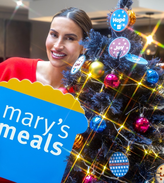 Ferne McCann with Mary's Meals sign next to Christmas Tree