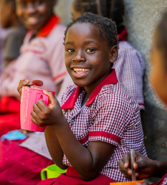 image of a happy child holding their school meal