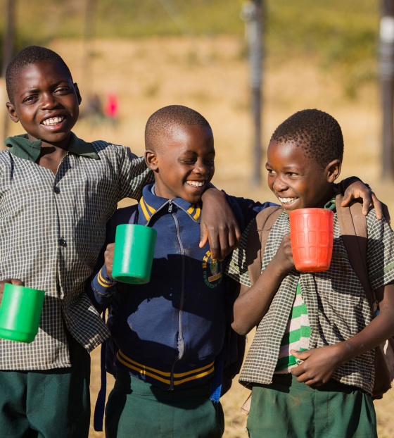Image of three children holding their school meals