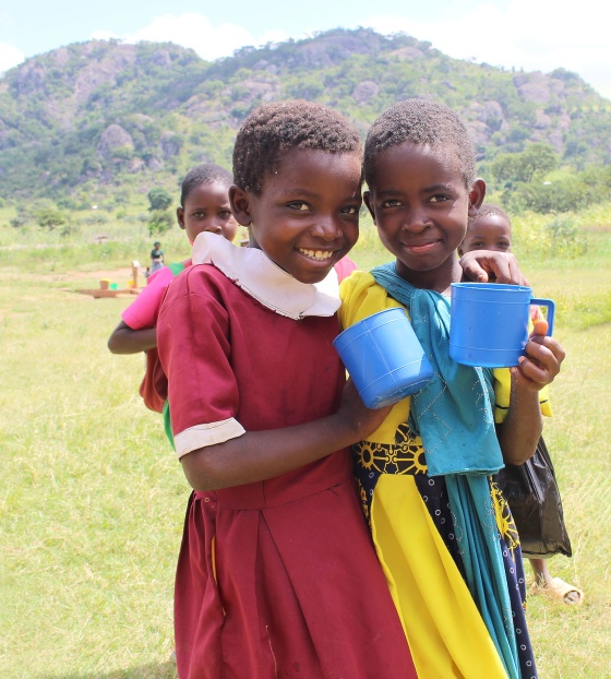 Image of children in Malawi holding mugs of porridge